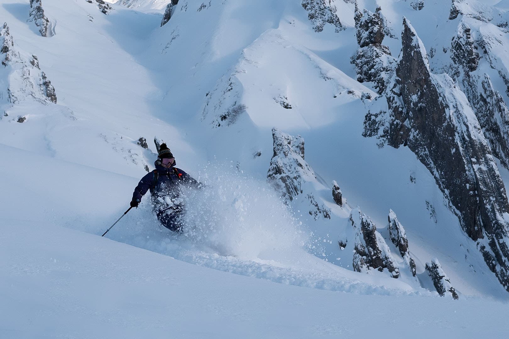 Ein Freerider im Tiefschnee unter den Felsflanken des Arlbergs.